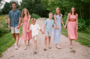 Miller family of four walking hand in hand on a forest path at Lowry Nature Center, Victoria MN